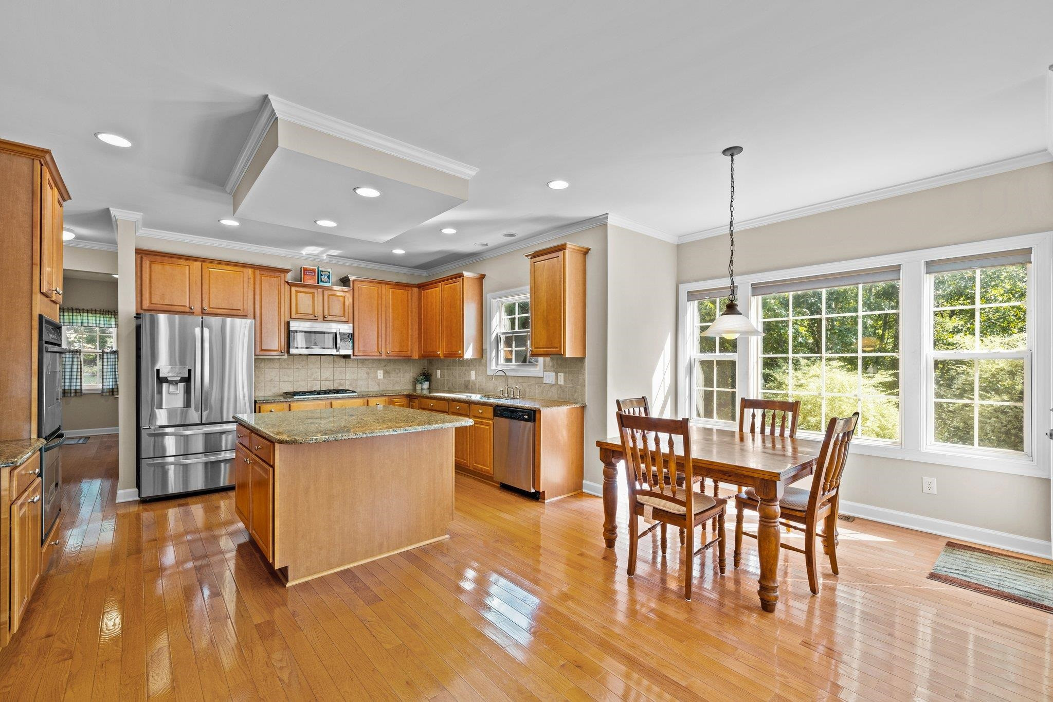11900 Deneb Court Raleigh, NC 27614 - Photo 18 of 60 a kitchen with stainless steel appliances granite countertop table chairs and wooden floor