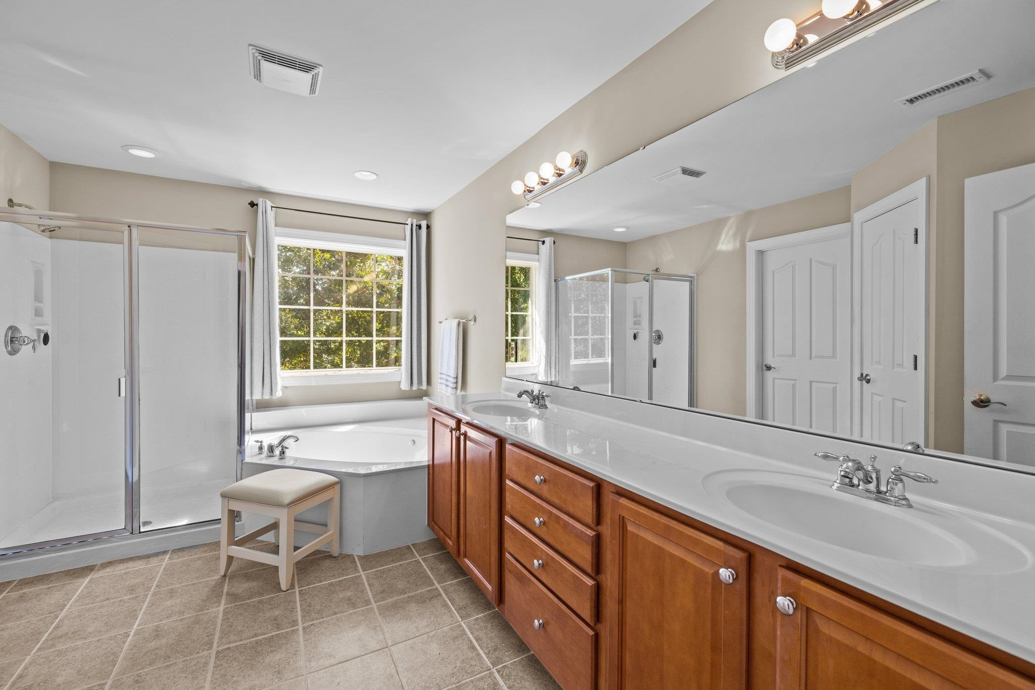 11900 Deneb Court Raleigh, NC 27614 - Photo 31 of 60 a spacious bathroom with a double vanity sink large mirror and a bathtub