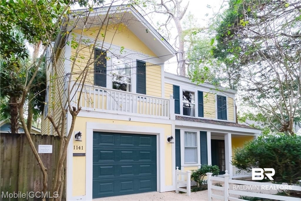 1141 Montauk Avenue Mobile, AL 36604 - Photo 2 of 15 View of front of house with stucco siding, a garage, fence, and a balcony