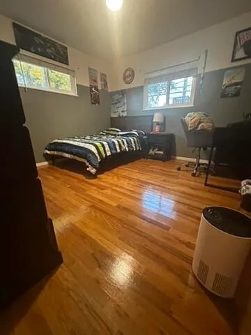 a room with gym equipment and wooden floor