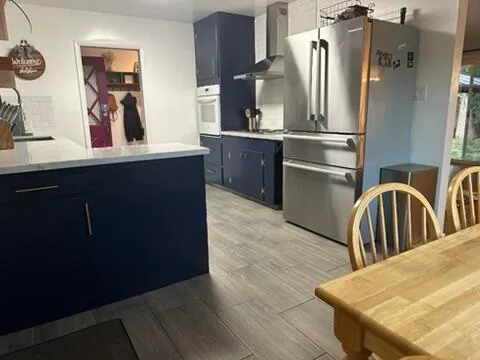 a kitchen with stainless steel appliances granite countertop a refrigerator a stove and a sink