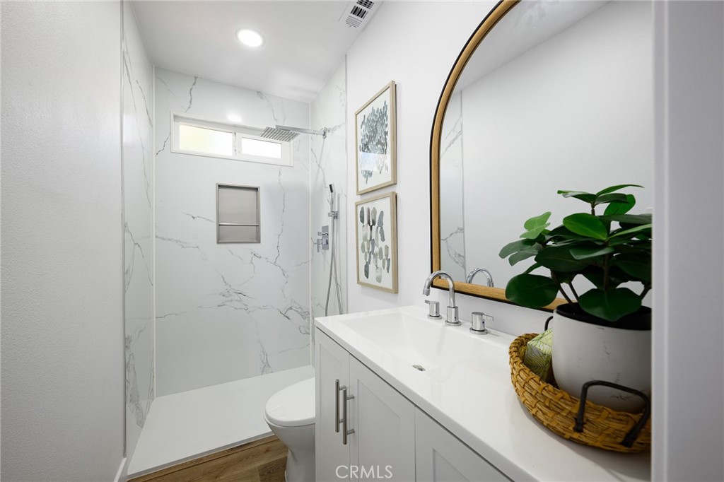 4705 East Washington Avenue Orange, CA 92869 - Photo 18 of 41 a bathroom with a sink a toilet and a mirror