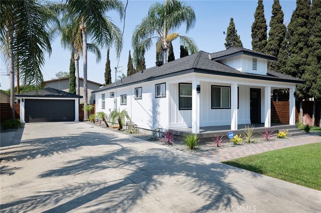 4705 East Washington Avenue Orange, CA 92869 - Photo 2 of 41 a view of a white house with a large windows and a yard with plants