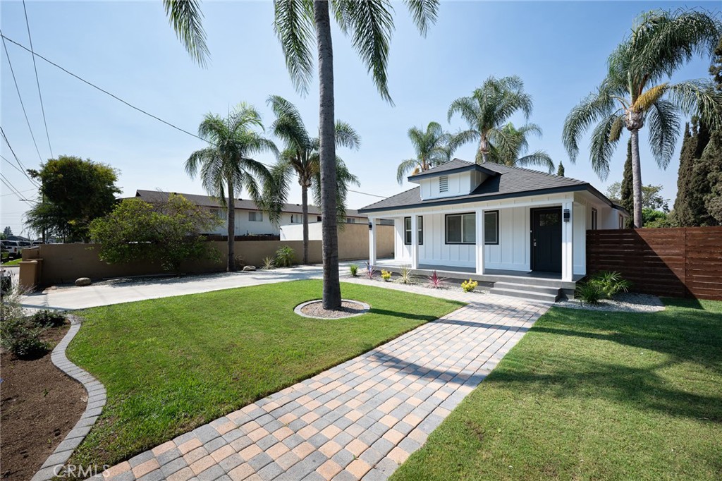 4705 East Washington Avenue Orange, CA 92869 - Photo 39 of 41 a front view of a house with a garden and trees
