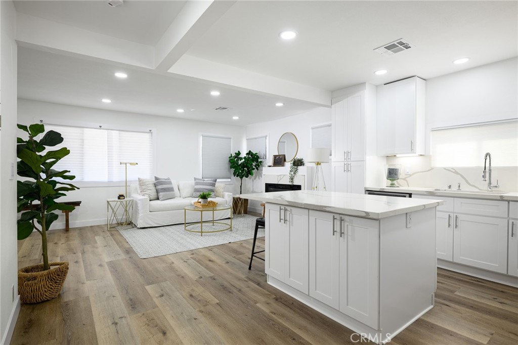 4705 East Washington Avenue Orange, CA 92869 - Photo 7 of 41 a kitchen with sink stove and white cabinets with wooden floor