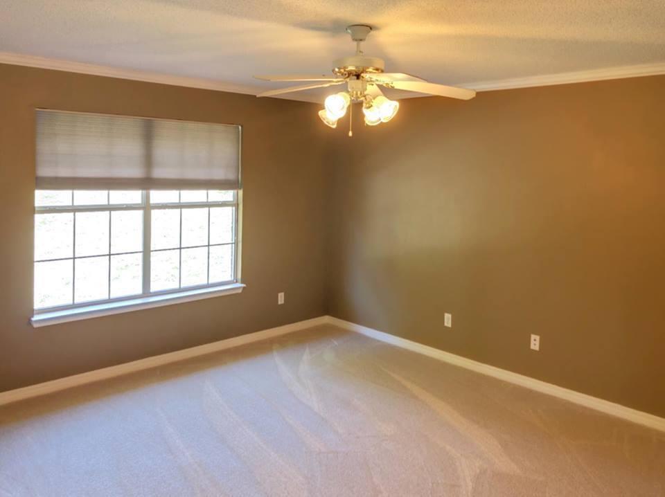 5196 Whitehurst Lane Crestview, FL 32536 - Photo 10 of 13 an empty room with a chandelier fan and windows