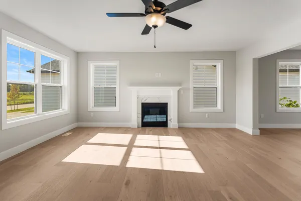 a view of an empty room with a window and fireplace