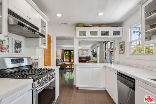 a kitchen with stainless steel appliances white cabinets and a stove top oven