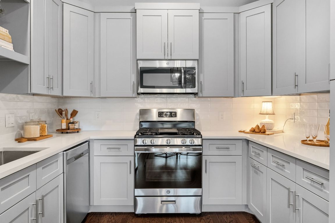 304 Blackson Avenue, Unit A Austin, TX 78752 - Photo 13 of 26 a kitchen with white cabinets and stainless steel appliances