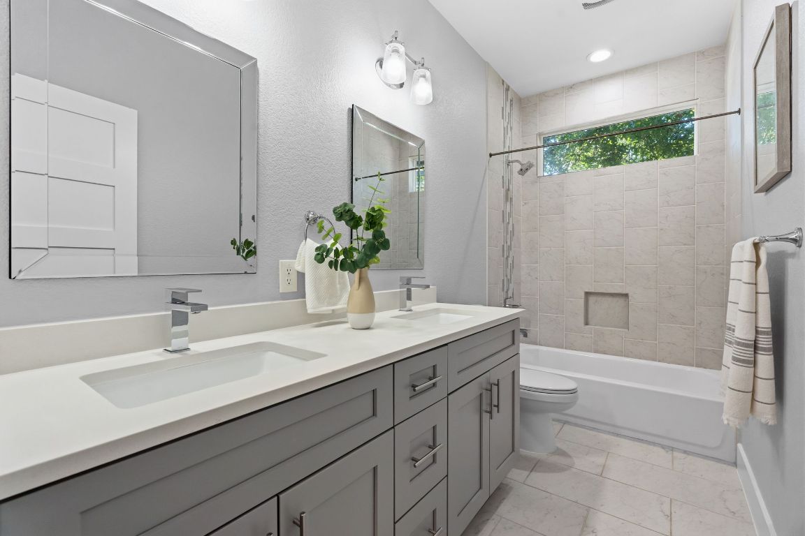 304 Blackson Avenue, Unit A Austin, TX 78752 - Photo 23 of 26 a bathroom with a granite countertop sink a mirror and a bathtub