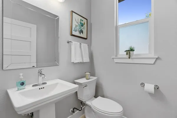 a bathroom with a sink mirror and toilet
