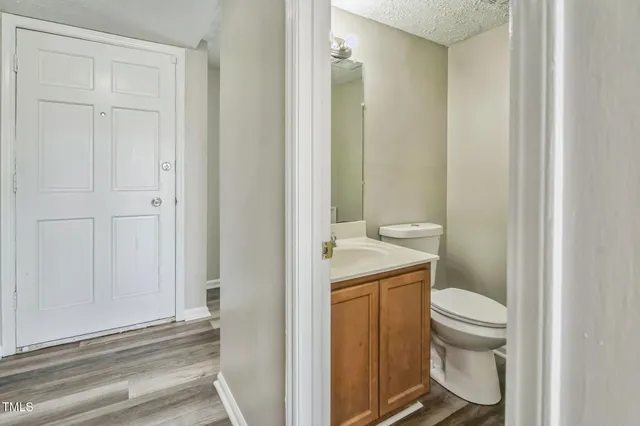 a bathroom with a granite countertop toilet and a sink