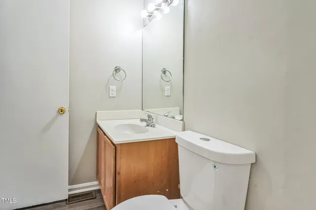 a bathroom with a toilet a sink and mirror