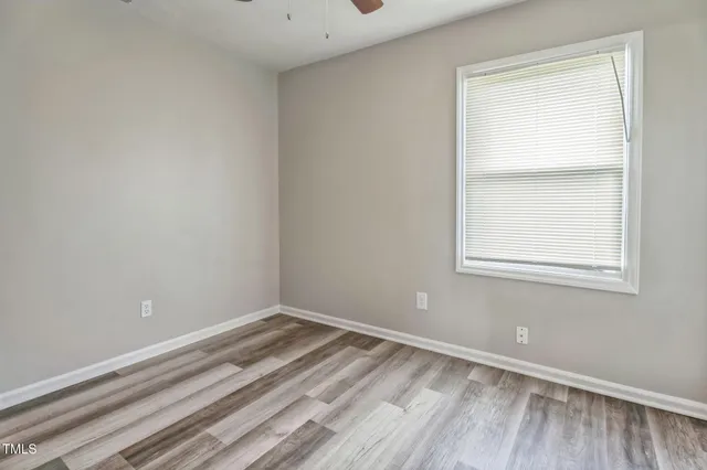 a view of a small space with wooden floor and a window