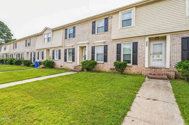 a front view of a house with garden and plants
