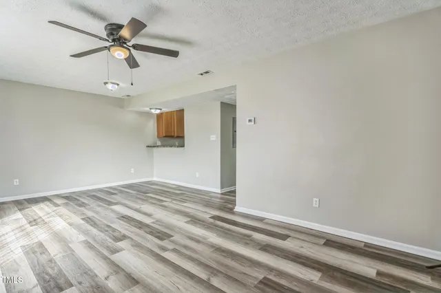 an empty room with ceiling fan and window