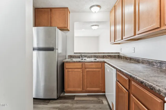a kitchen with stainless steel appliances granite countertop a refrigerator and a sink