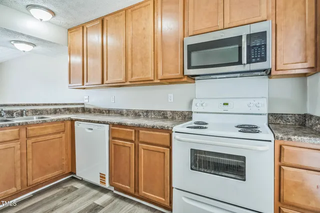 a kitchen with granite countertop cabinets stainless steel appliances and wooden floor