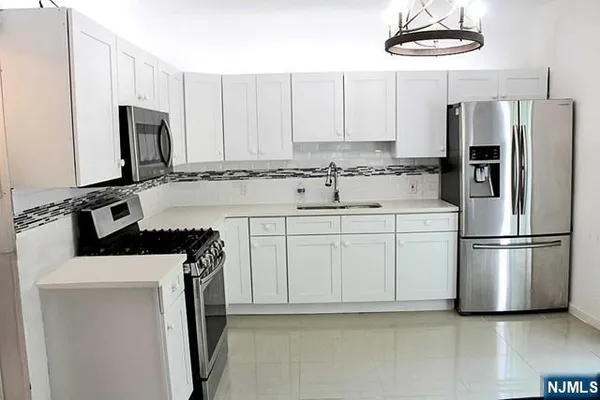 a kitchen with stainless steel appliances a refrigerator sink and cabinets