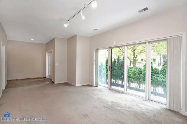 a view of an empty room with wooden floor and a sliding door