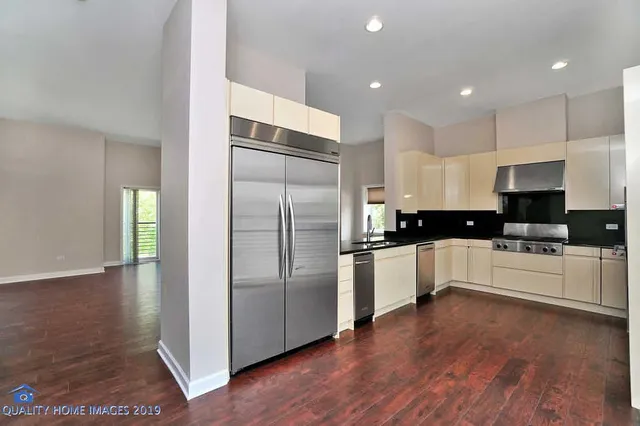a kitchen with a refrigerator and white cabinets