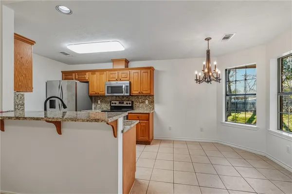 a view of cabinets and kitchen with a sink wooden floor and windows