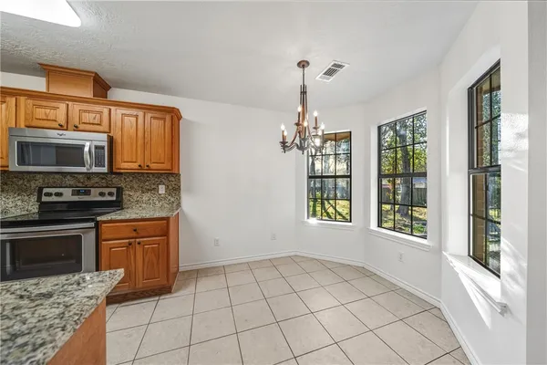 a kitchen with granite countertop a stove cabinets and microwave