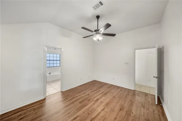 a view of a room with wooden floor and a ceiling fan