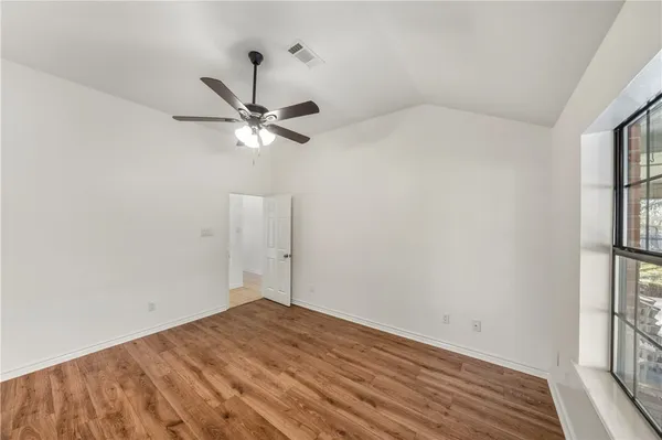 a view of a room with a ceiling fan and a window