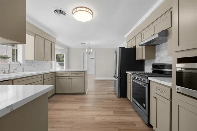 a kitchen with stainless steel appliances granite countertop a sink and dishwasher with white cabinets
