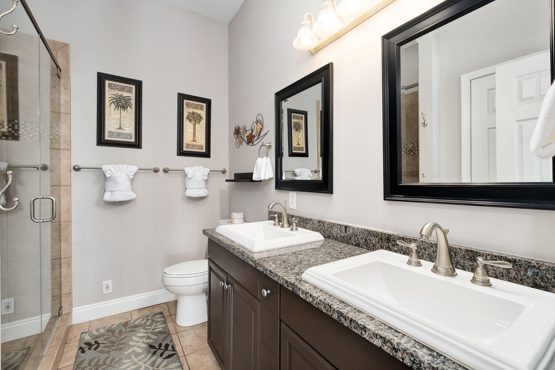 172 Sugar Sand Lane Santa Rosa Beach, FL 32459 - Photo 29 of 40 a bathroom with double vanity sinks a toilet a mirror and shower