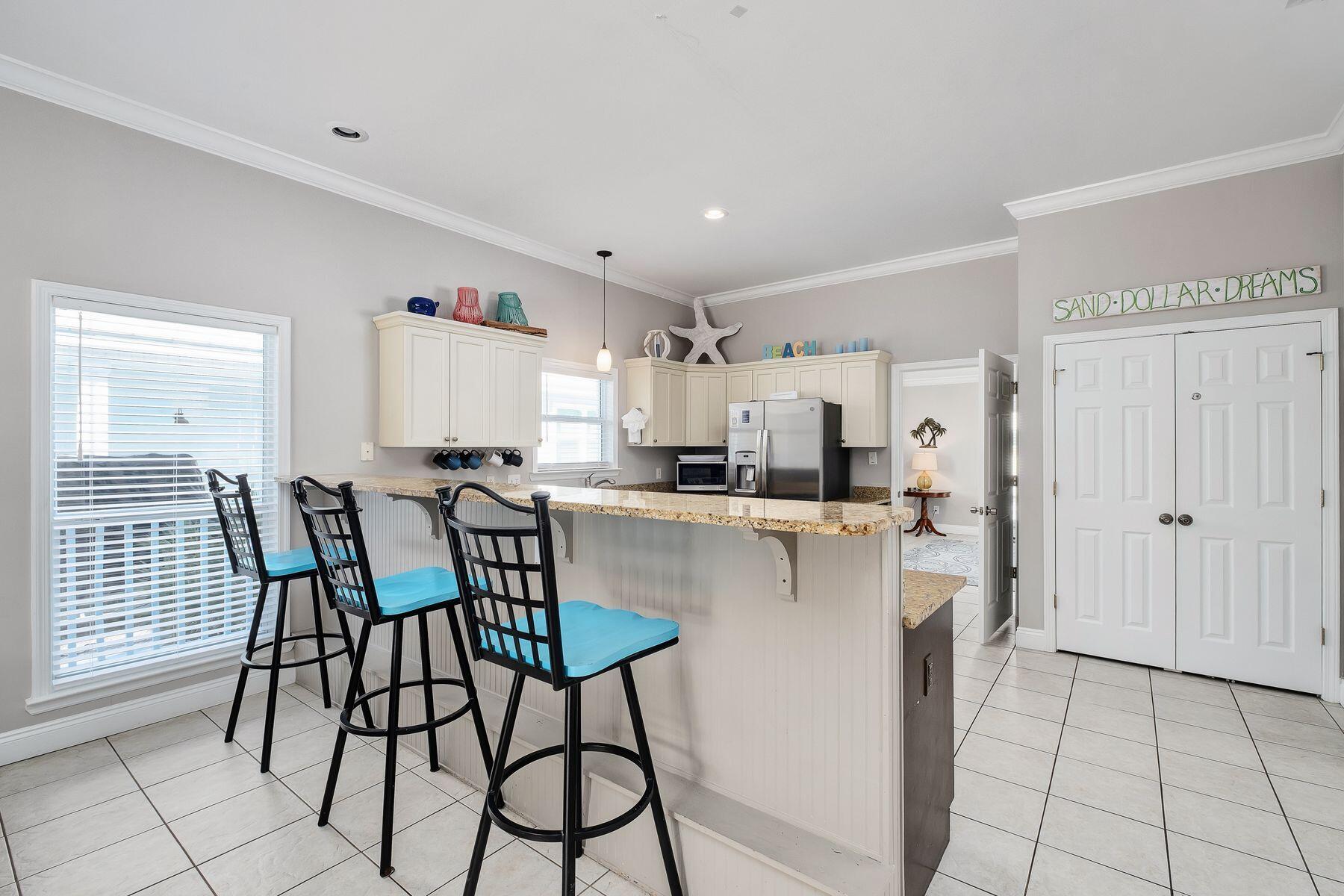 172 Sugar Sand Lane Santa Rosa Beach, FL 32459 - Photo 7 of 40 a kitchen with stainless steel appliances a dining table chairs and a refrigerator