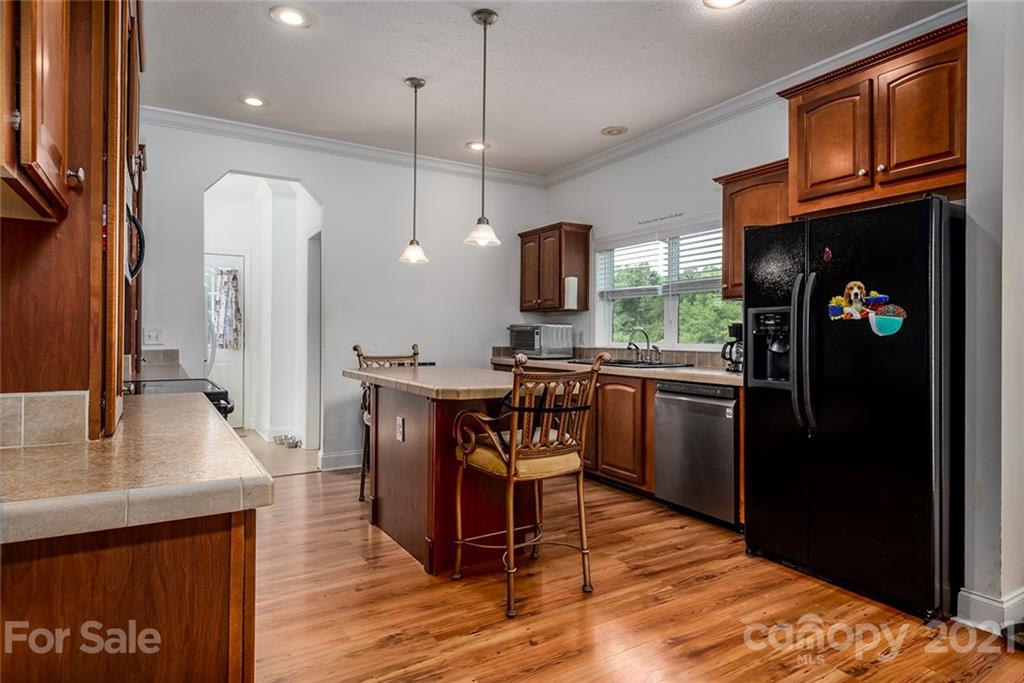 4478 Hickory Nut Ridge Road Hudson, NC 28638 - Photo 24 of 29 a kitchen with stainless steel appliances granite countertop a refrigerator a sink dishwasher a stove and a dining table with wooden floor