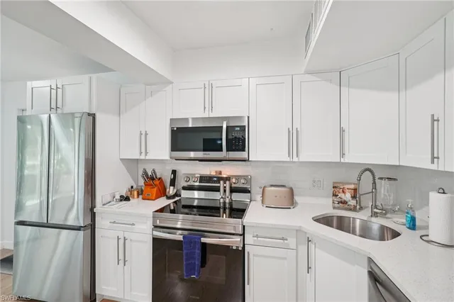 a kitchen with stainless steel appliances a refrigerator sink and cabinets