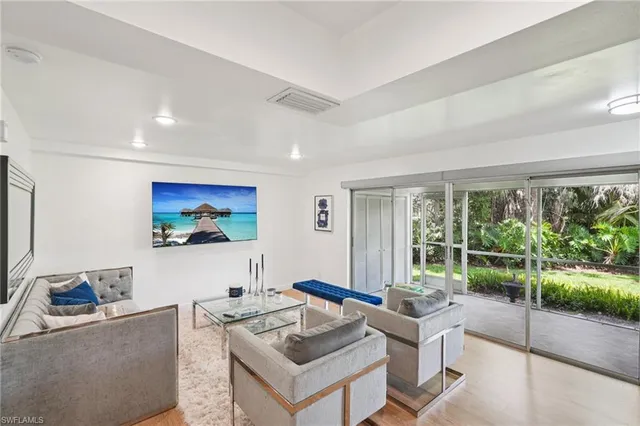 a living room with furniture a large window and a flat screen tv