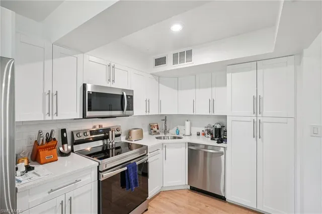 a kitchen with white cabinets and white appliances