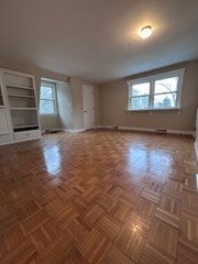 38 Cedar Street, Unit 1 Holliston, MA 01746 - Photo 7 of 15 an empty room with wooden floor fireplace and windows