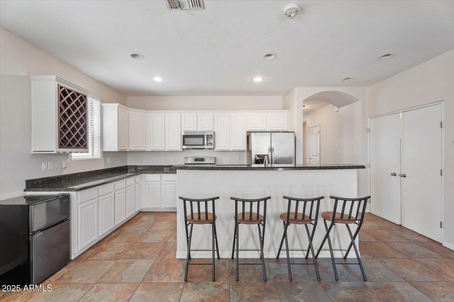1423 South Newberry Lane Tempe, AZ 85281 - Photo 4 of 19 a kitchen with stainless steel appliances granite countertop a sink and a refrigerator