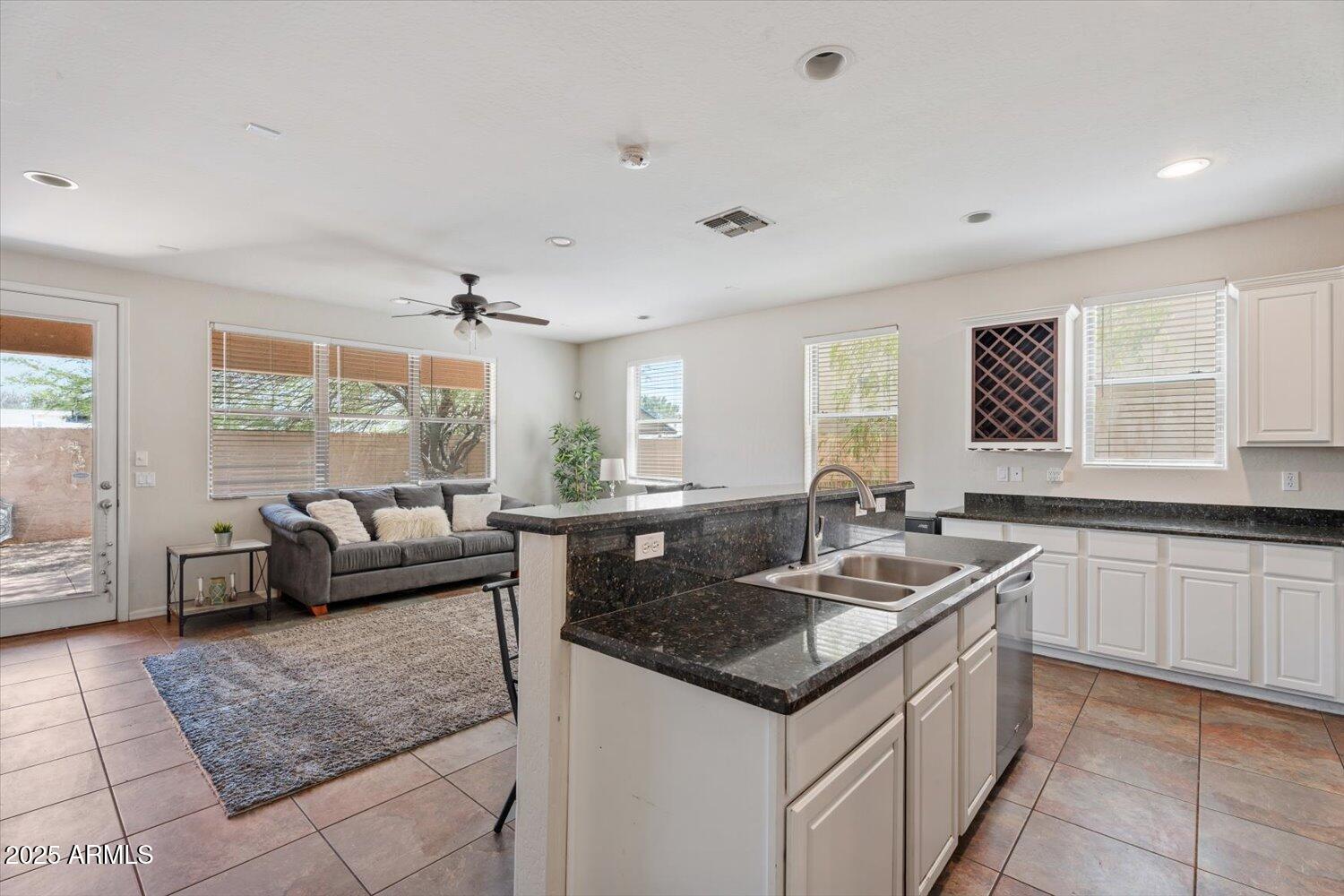 1423 South Newberry Lane Tempe, AZ 85281 - Photo 5 of 19 a kitchen with granite countertop a sink and white cabinets