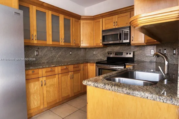 a kitchen with stainless steel appliances granite countertop a sink stove and microwave