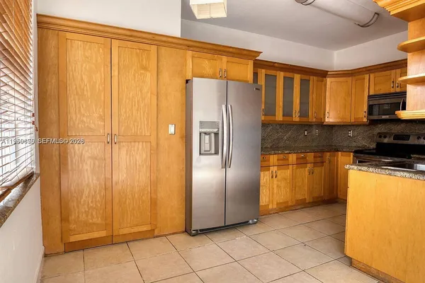 a kitchen with stainless steel appliances granite countertop a refrigerator and a stove top oven