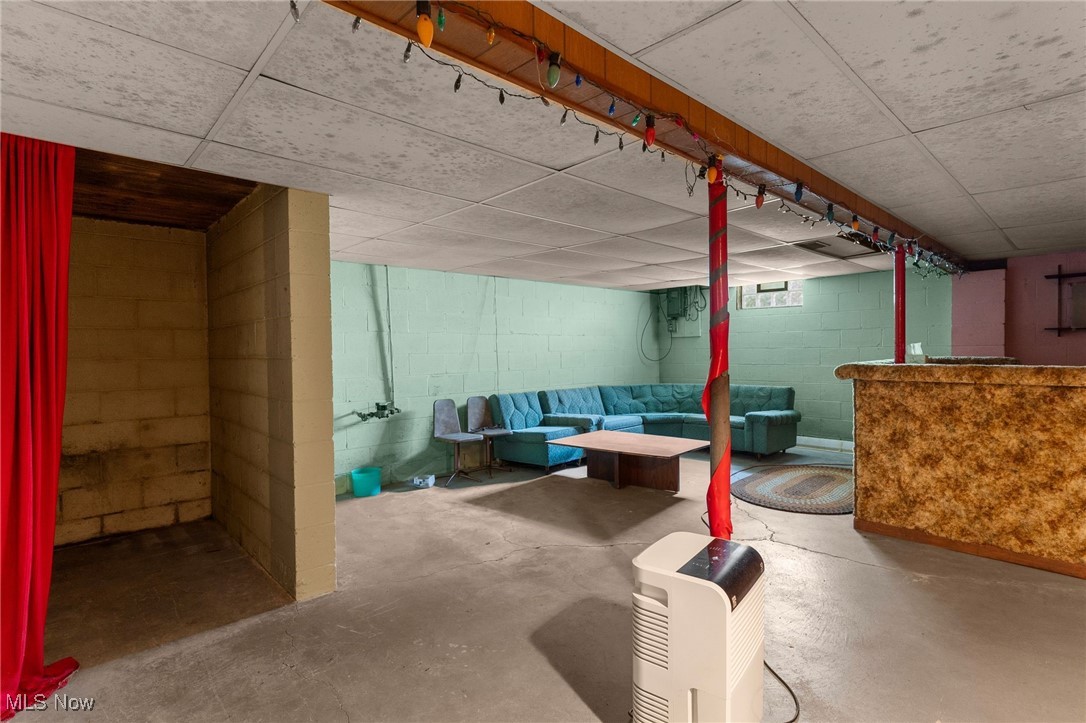 3907 Edwards Street Mineral Ridge, OH 44440 - Photo 35 of 45 Finished basement featuring a bar, a paneled ceiling, and concrete block wall