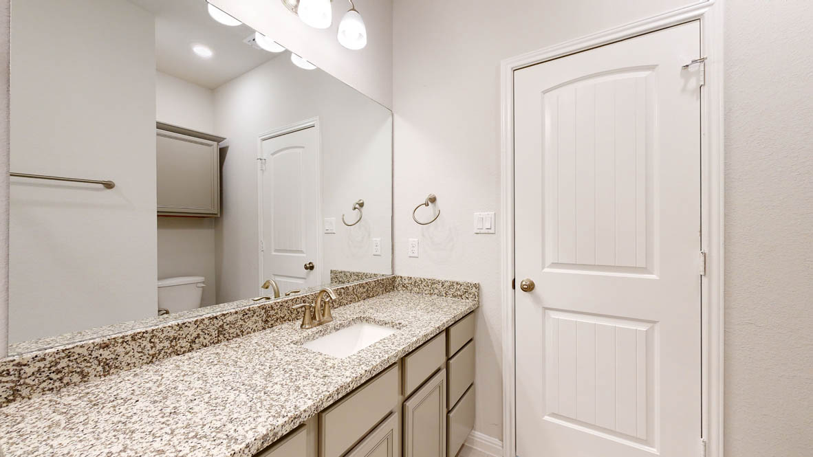 808 Gauge Road Thorndale, TX 76577 - Photo 30 of 31 A pristine bathroom features a vanity with granite counters and a clean white sink, accented by modern fixtures.