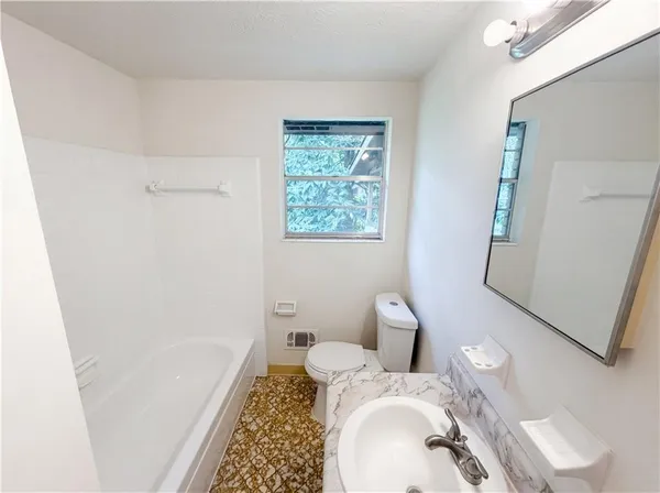 a bathroom with a toilet sink and mirror