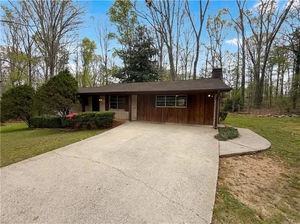 a view of a house with backyard and trees
