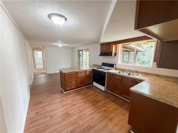 a kitchen with stainless steel appliances granite countertop a stove a sink and a refrigerator