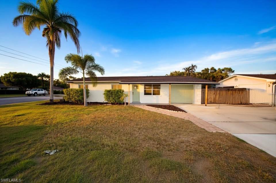 Single story home with concrete driveway and an attached garage