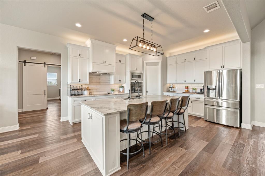 175 County Road 1109 Decatur, TX 76234 - Photo 11 of 39 a kitchen with stainless steel appliances a dining table chairs refrigerator and sink