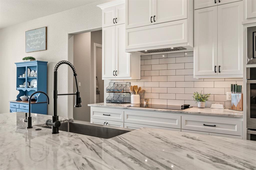 175 County Road 1109 Decatur, TX 76234 - Photo 15 of 39 a kitchen with granite countertop a sink and a stove top oven