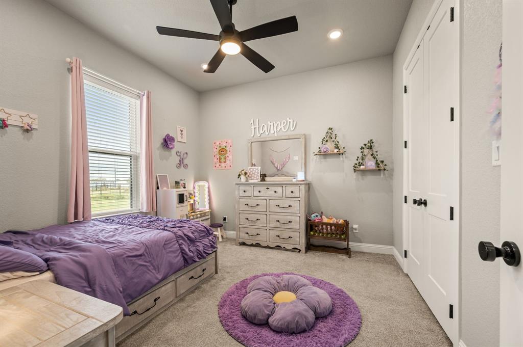 175 County Road 1109 Decatur, TX 76234 - Photo 23 of 39 a spacious bedroom with a bed and a chandelier